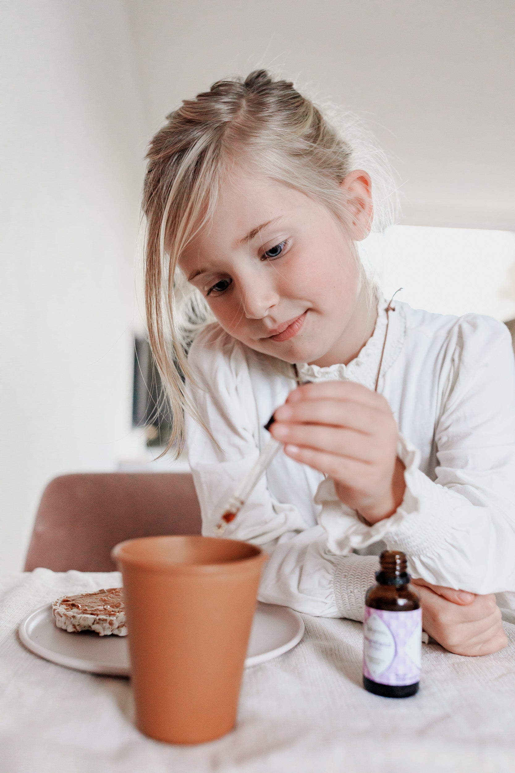 Kinderthee: meisje doet weerstand drops van Laveen in haar thee