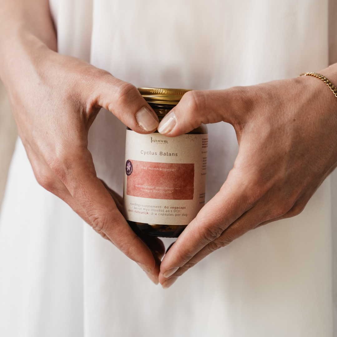 Een sfeerfoto van het supplement vastgehouden voor de onderbuik van een vrouw.