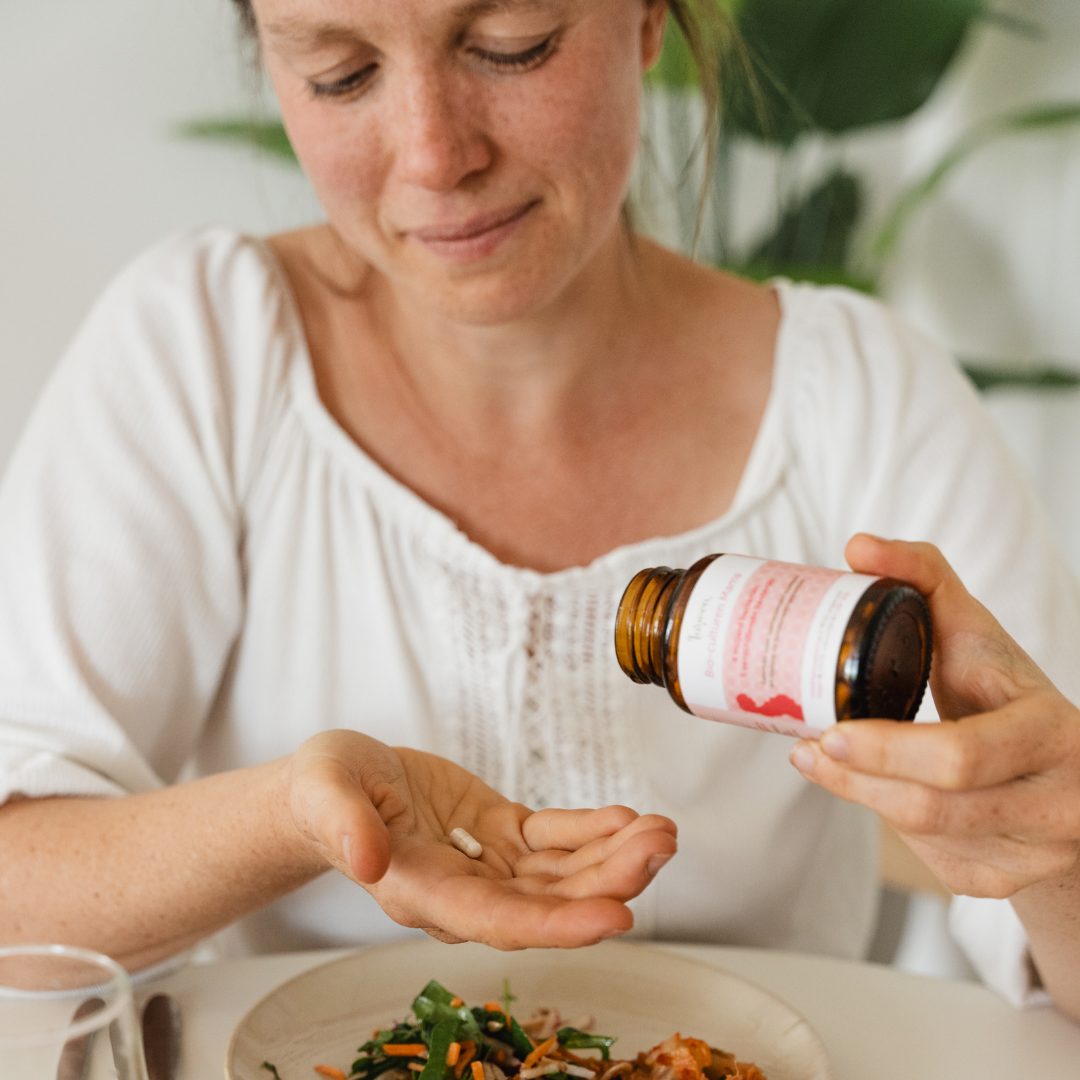 Sfeerfoto van de Bio Culturen Mama, een model neemt een capsule in haar hand.