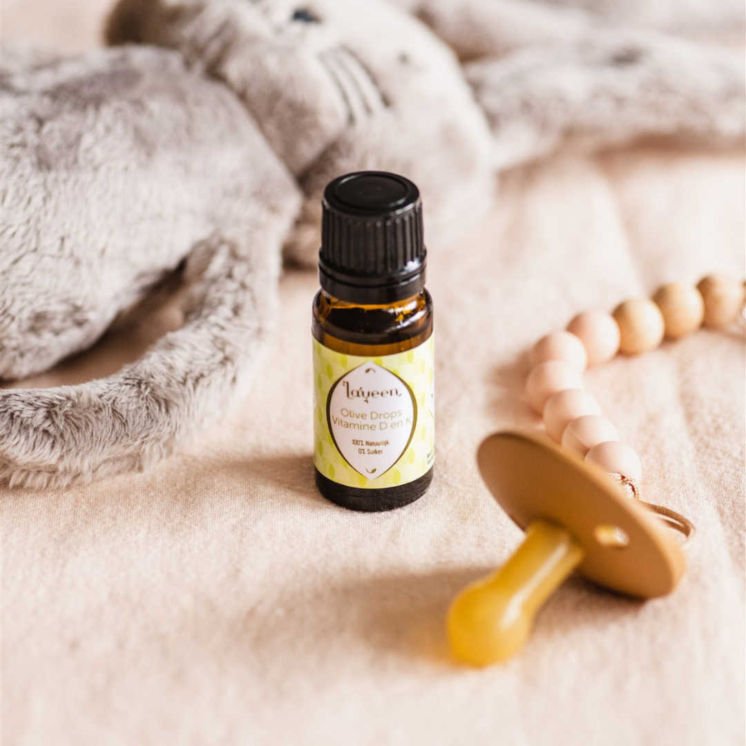 Sfeerfoto van de vitamine D en K druppels naast een speentje.