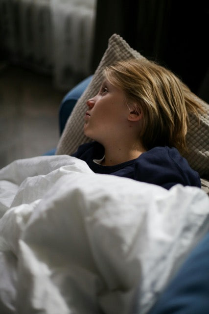 griep of verkoudheid? Een kind op bed.