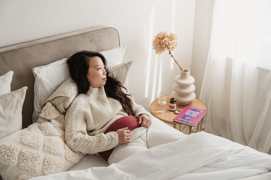 laag progesteron: vrouw op bed met een boek over hormonale balans