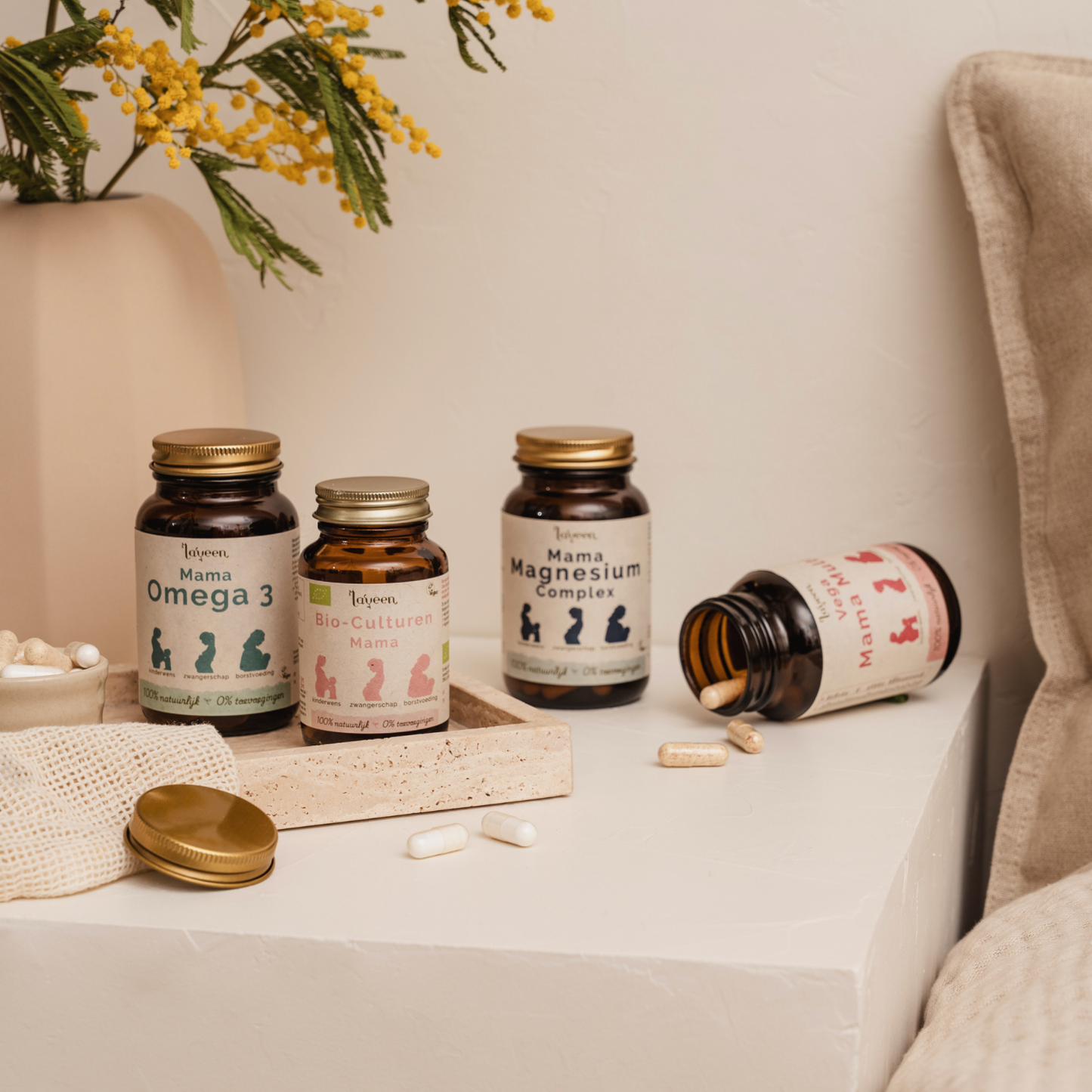 Sfeerfoto van de vier supplementen van Laveen voor vrouwen in hun laatste trimester tijdens de zwangerschap: De Mama Omega 3, Bio-Culturen Mama, Mama Magnesium complex en Vega Mama Multi.