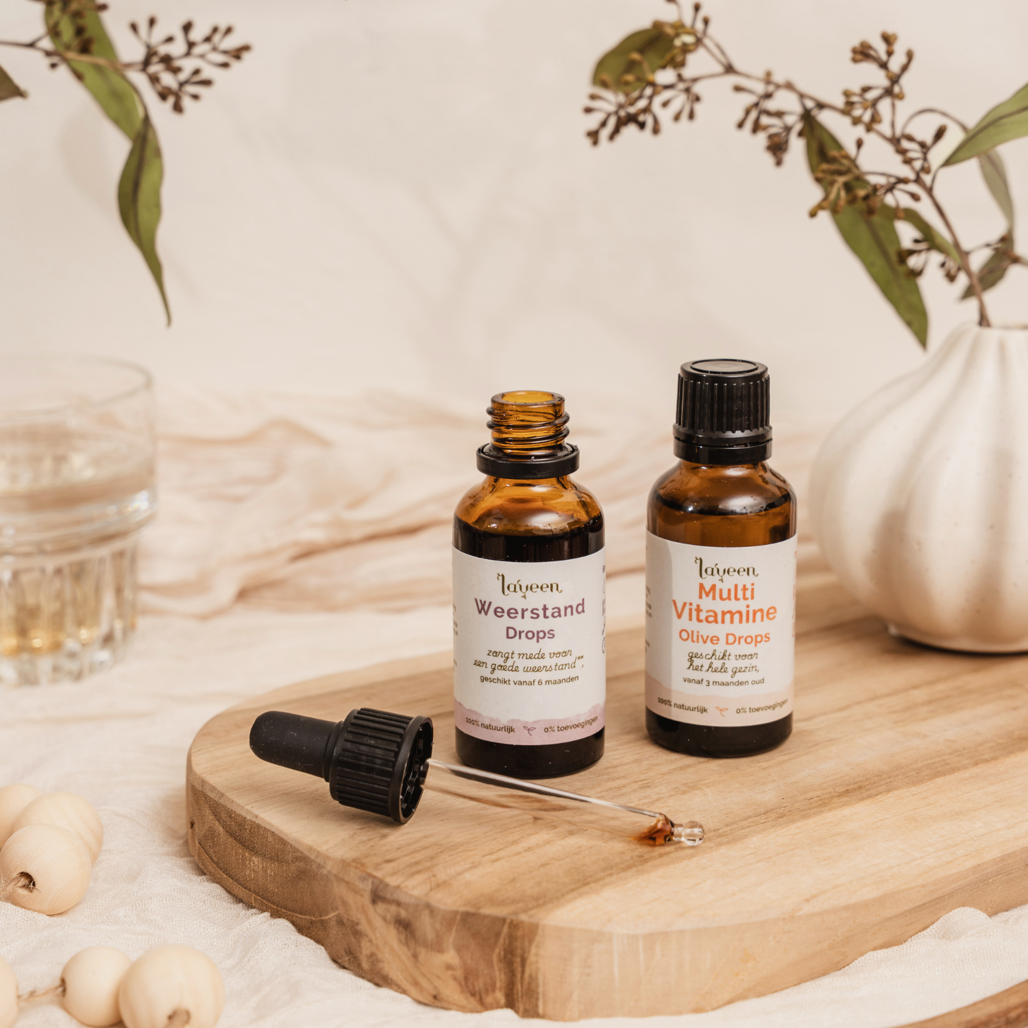 Sfeerfoto van de voordeelbundel Kind Compleet van Laveen met een glazen pipetflesje Weerstand drops en een glazen druppelflesje Multi Vitamine Olive Drops.