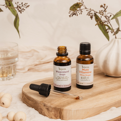 Sfeerfoto van de voordeelbundel Kind Compleet van Laveen met een glazen pipetflesje Weerstand drops en een glazen druppelflesje Multi Vitamine Olive Drops.