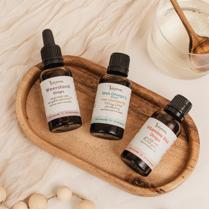 Sfeerfoto van de voordeelbundel Vega Kind Compleet van Laveen. Met de Weerstand Drops in een glazen pipetflesje, De DHA Omega 3 Drops en de Vitamine B12 drops, allebei in een glazen druppelflesje.