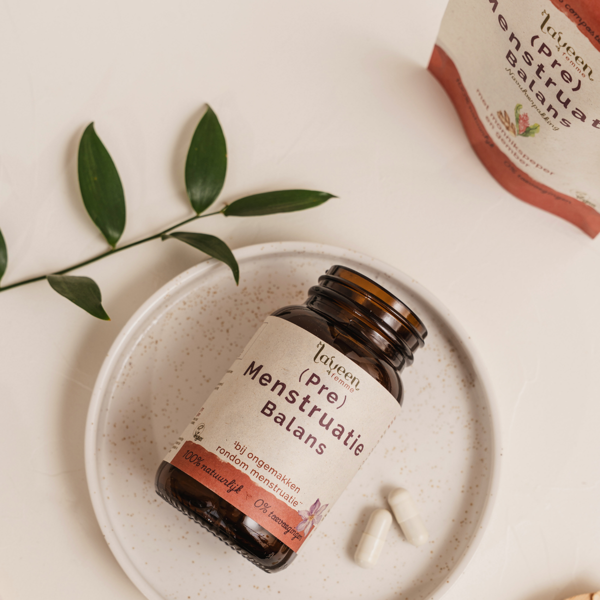 Laveen (Pre) Menstruatie Balans capsules naast glazen pot en navulverpakking, supplement met monnikspeper voor ondersteuning rond de menstruatie.